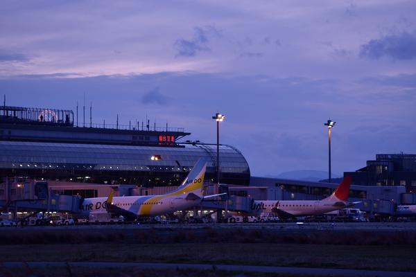 青い時間と人工光が重なり、印象が強く見える空港の写真
